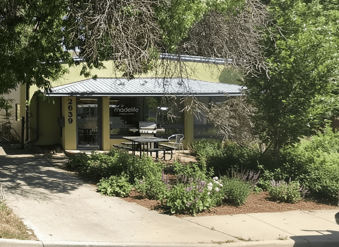 Yellow single-storey building numbered 2639, with a metal awning and a garden in front