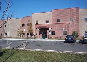 The two-story brick ICCS Weld building and its parking lot